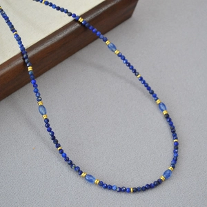 Dettaglio macro di perle di sodalite sfaccettate e distanziatori dorati sulla collana