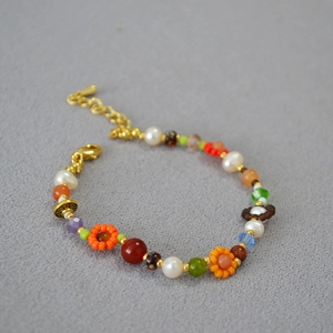 Détail du collier de perles fait main avec fleurs colorées, perles et fermoir doré