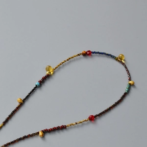 Detailed view of colorful beads necklace with transparent yellow teardrop charms