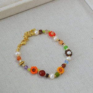 Détail du collier de perles avec fleurs colorées, perles et fermoir mousqueton doré chic