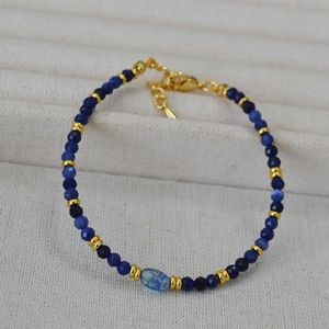 Dettaglio macro di perline di sodalite blu sfaccettate con distanziatori dorati e chiusura
