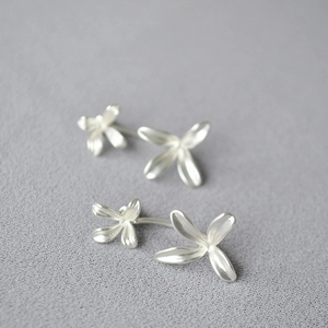 Detailed macro of vintage silver detachable flower earrings with brushed metal finish
