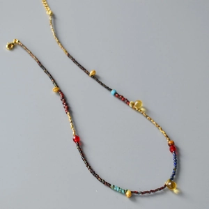 Detail of bohemian handmade beaded necklace with multi-color beads and gold lobster clasp