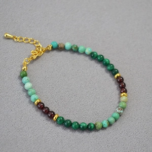 Détail macro du collier de perles en turquoise malachite grenat et intercalaires dorés