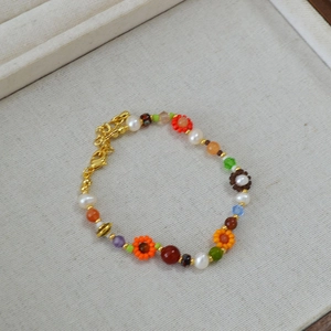 Détail du collier de perles colorées avec perles d'eau douce et breloques florales