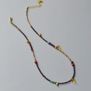 Detail of beaded necklace with yellow teardrop beads and bohemian style metal clasp