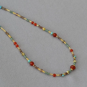 Detailed macro view of handmade ethnic beaded necklace with red agate and turquoise stones