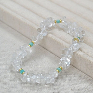 Detail of beaded necklace with irregular clear crystals, blue stone beads and gold accents