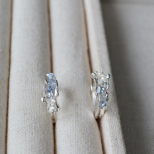 S925 silver hoop earrings with hammered texture and light blue stones on a jewelry tray