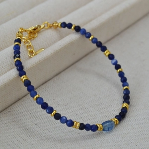 Dettaglio della collana con pietre blu sfaccettate, perla a botte e chiusura dorata