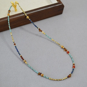 Detail of beaded necklace featuring turquoise, red agate and golden lobster clasp