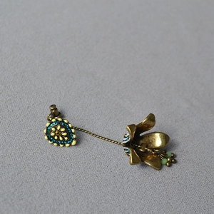 Detail of vintage bohemian tassel earrings with blue crystals and floral metal charms