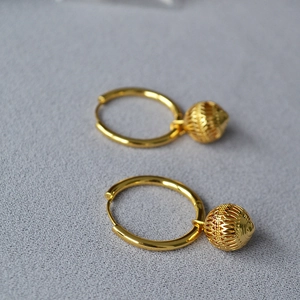 Boucles d'oreilles créoles dorées style lanterne ajourée vintage pour femme sur gris