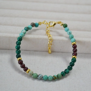 Détail du collier de perles malachite et turquoise avec fermoir mousqueton doré et chaîne
