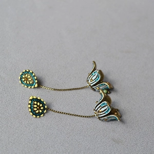 Detailed macro view of Bohemian floral drop earrings with blue enamel and gold finish
