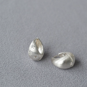 Brushed silver star earrings with sparkling zircon stones in a minimalist hoop style
