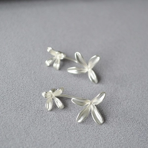 Detailed view of silver flower earrings with elegant matte finish and floral petal design