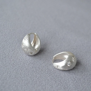Minimalist silver hoop earrings with brushed metal texture and sparkling star zircon accents