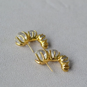Golden C-shaped earrings with translucent glass gradient balls in claw setting