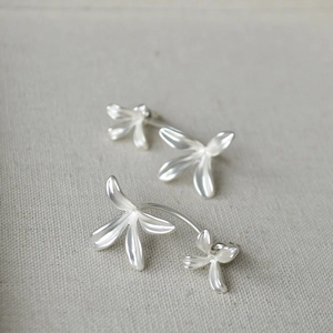 Minimalist vintage matte silver orchid flower stud earrings on rustic linen background