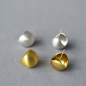 Detail of brushed gold and silver hollow hemispherical stud earrings in 2x2 layout