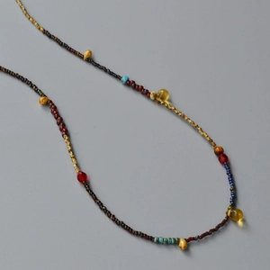 Detail of colorful beaded necklace with yellow teardrop beads and bohemian glass charms