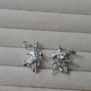 Détail des boucles d'oreilles 3D irrégulières en forme de fleur au fini argent poli