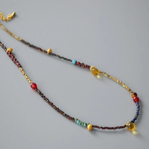 Detailed macro view of colorful handmade beads and yellow teardrop pendant necklace