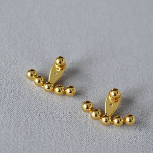 Vista detallada del pendiente ear jacket bañado en oro pulido con diseño de cuentas finas