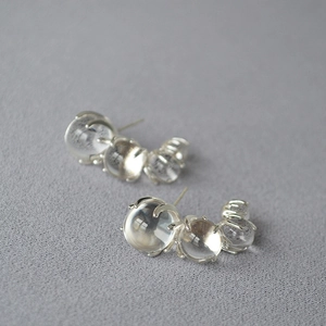 Detailed macro view of S925 silver C-shaped earrings with clear gradient glass beads