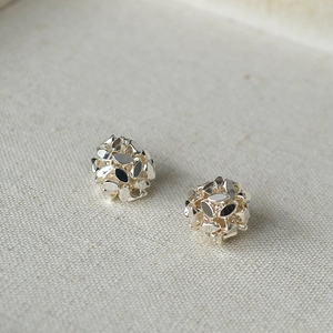 Macro shot of silver cluster earrings showing multifaceted metallic spheres in detail