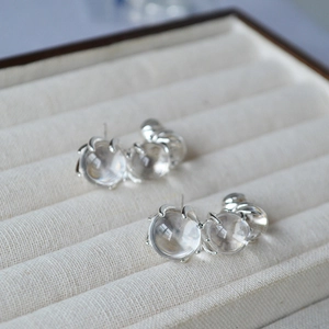 Detail of gradient glass spheres on C-shaped silver earrings with elegant claw setting