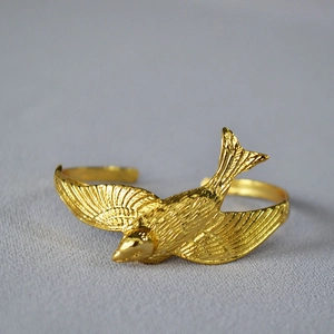 Detailed close-up of a 3D flying swallow bangle with intricate gold-plated feather texture