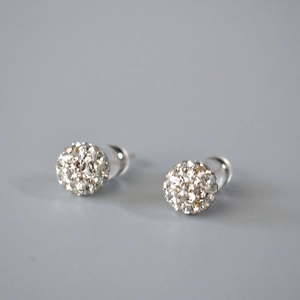 Macro detail of sparkling pavé disco ball stud earrings with 925 silver needle post