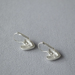 Vue détaillée des boucles d'oreilles cœur en argent avec finition miroir et fermoir levier