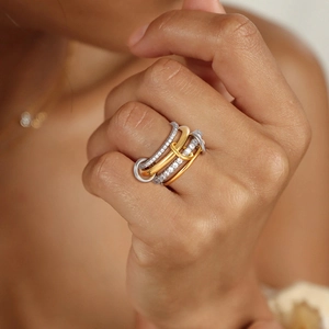 Macro detail of multi-layer interlocking rings featuring mixed metal tones and pavé crystals