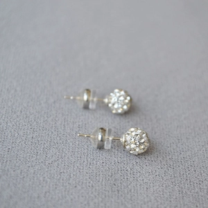 Macro shot of 925 silver stud earrings with sparkling pave-set crystal disco balls