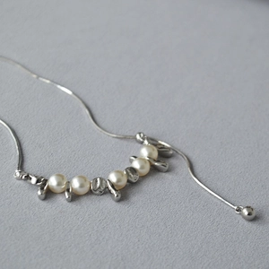 Dettaglio catena serpente argento con perle bianche e grani metallici irregolari