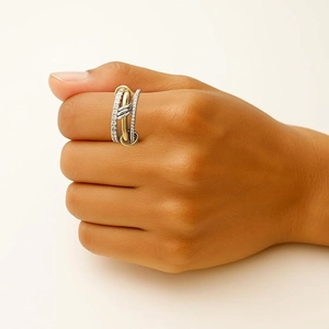 Detail of layered wrap ring featuring gold and silver bands with pavé set diamonds