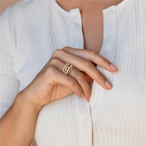 Close-up of a layered gold ring with micro-pave crystals on a model's hand