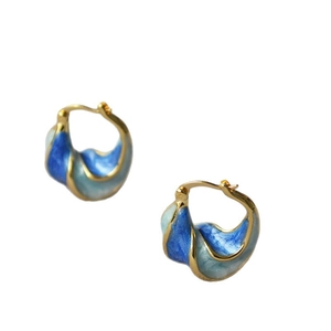 Artistic spiral earrings with blue enamel and gold finish on a clean white background