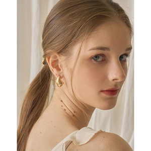 Close-up of elegant gold water drop earrings on model for a minimalist style