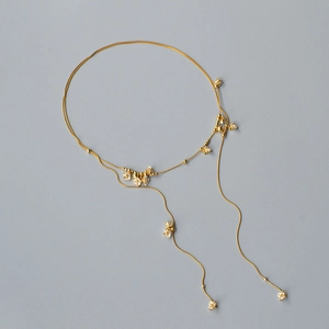 Dettaglio della collana a doppio strato in oro 18K con fiori di cristallo e nappe