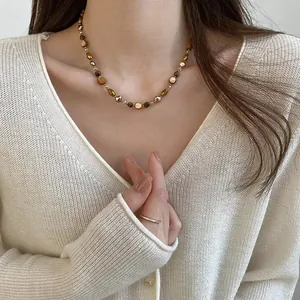 Detail of vintage Maillard necklace with amber tiger eye beads on female model