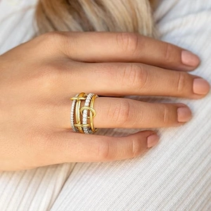Detail of multi-layered interlaced rings with pave diamonds and two-tone gold finish