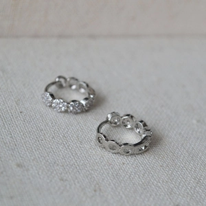 Macro shot of silver plated mini hoop earrings featuring pavé cubic zirconia settings