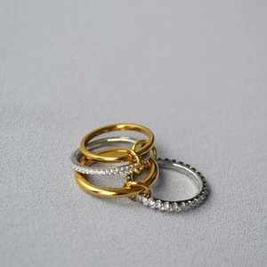 Detail of stacked multi-layer rings with gold and silver bands and pavé set zircons