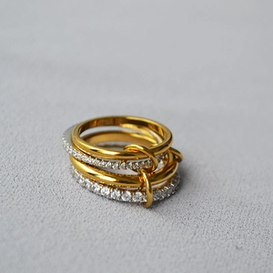 Macro view of multi-layer linked rings with gold finish and sparkling zircon stones