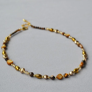 Detailed view of handmade beaded necklace with tiger eye stones and amber beads