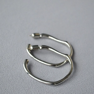 Irregular silver hoop earrings with high-polish finish and minimalist organic design
